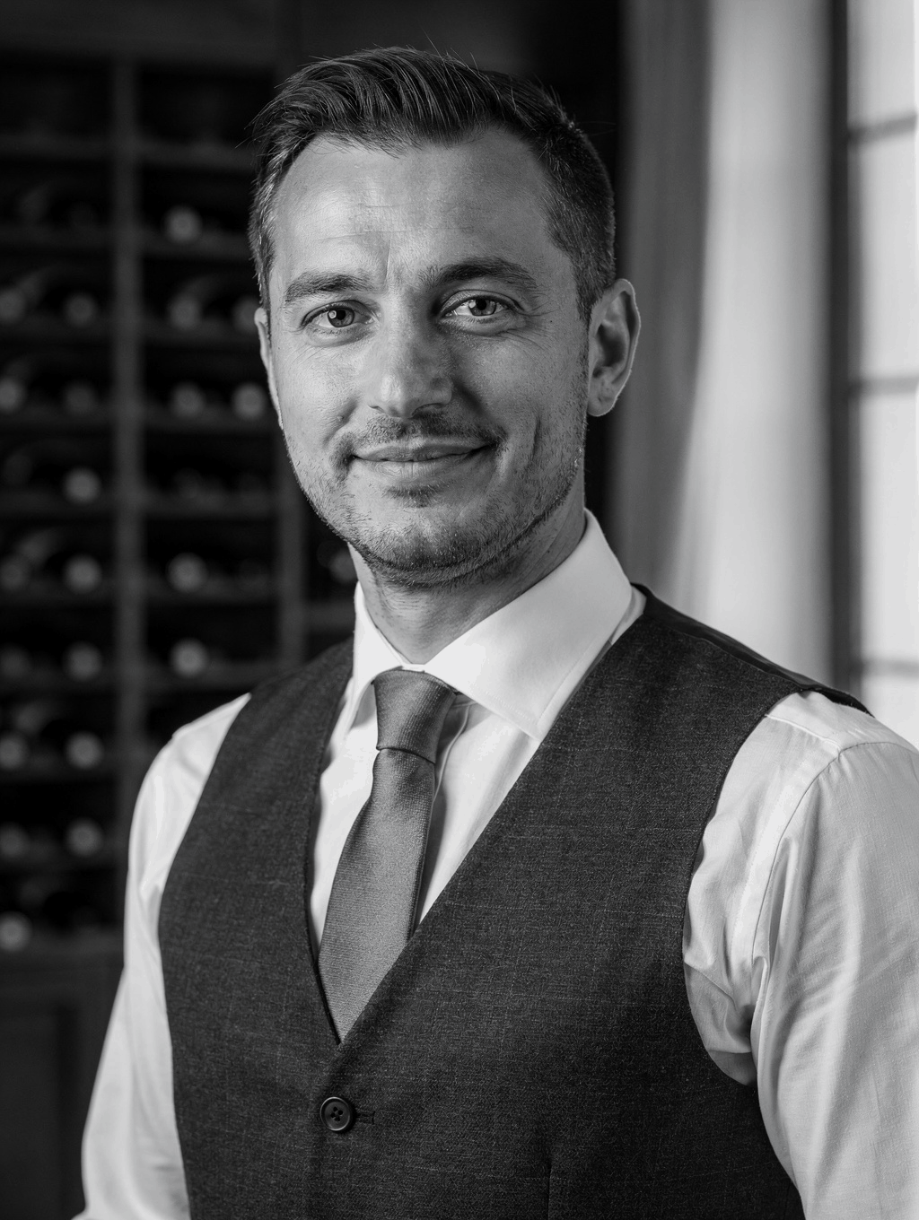Luca Romano selecting a bottle from the wine cellar
